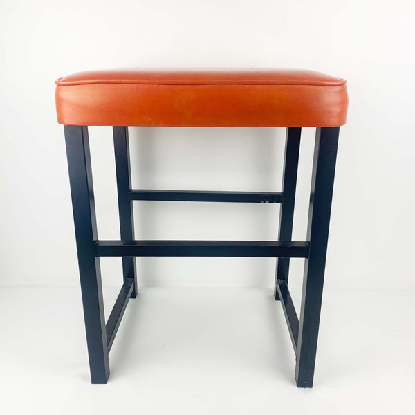 Upholstered mid century orange vinyl stool with black metal legs