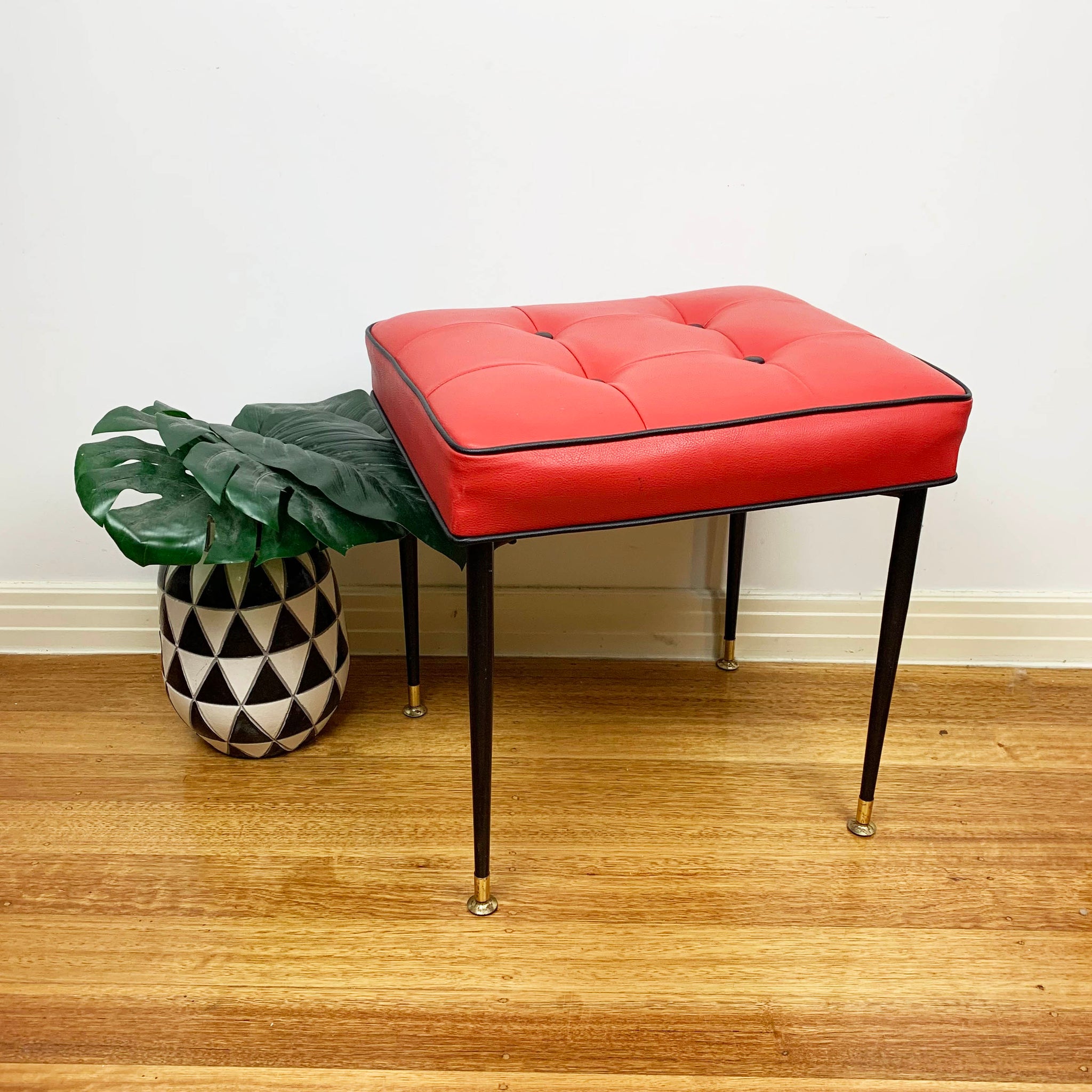 Mid century red vinyl stool with black button tufting